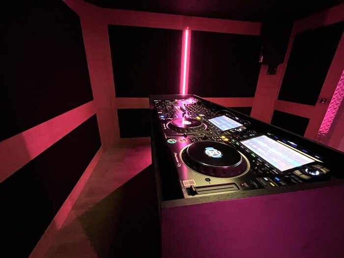 Trois platines CDJ dans un studio DJ éclairé