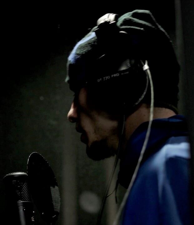 Rappeur portant un casque devant un micro dans une cabine vocale d'enregistrement