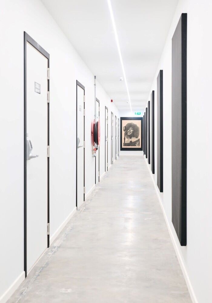 © Plug The Jack Music studio corridor with white walls and doors and black acoustic panels. | © Plug The Jack
