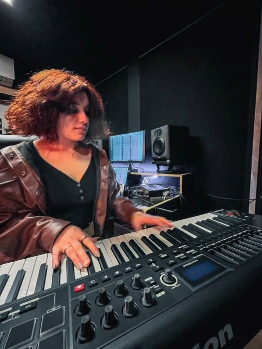 Pianist producing music in recording studio with Novation master keyboard and audio production screen. | © Plug The Jack