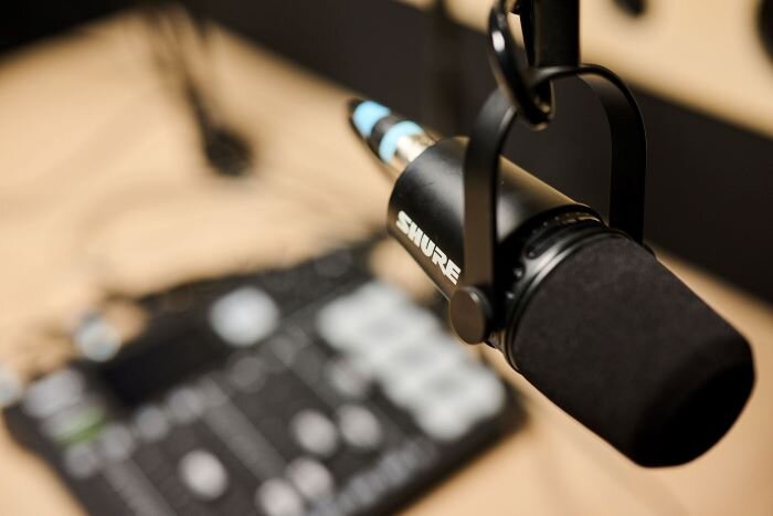 Shure MV7 microphone in podcast studio with Rodecaster Pro console in the background. | © Plug The Jack