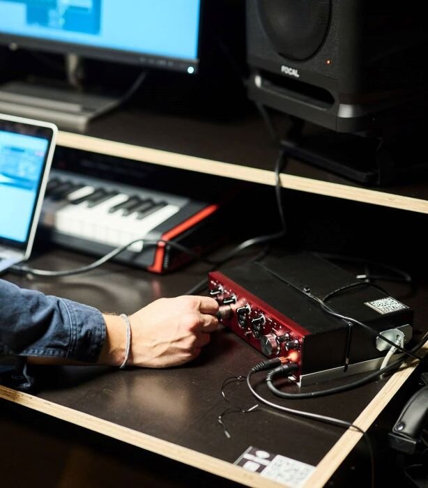 Réglages sur interface audio Focusrite dans studio d'enregistrement avec enceinte et clavier maître. | © Plug The Jack