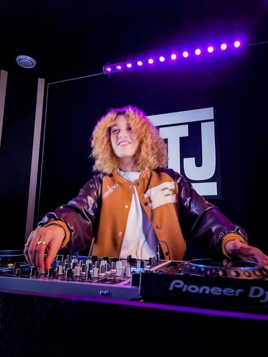 Vrouw voor Pioneer CDJ-3000-spelers in DJ-muziekstudio met lichten bij mij in de buurt. | © Plug The Jack
