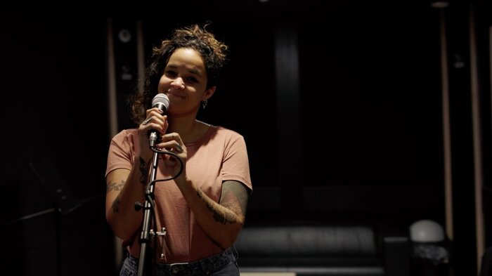 Zangeres aan de microfoon in een Plug The Jack-studio
